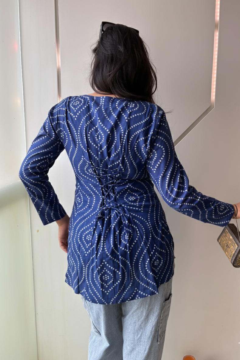 Person wearing a blue patterned top with a white background