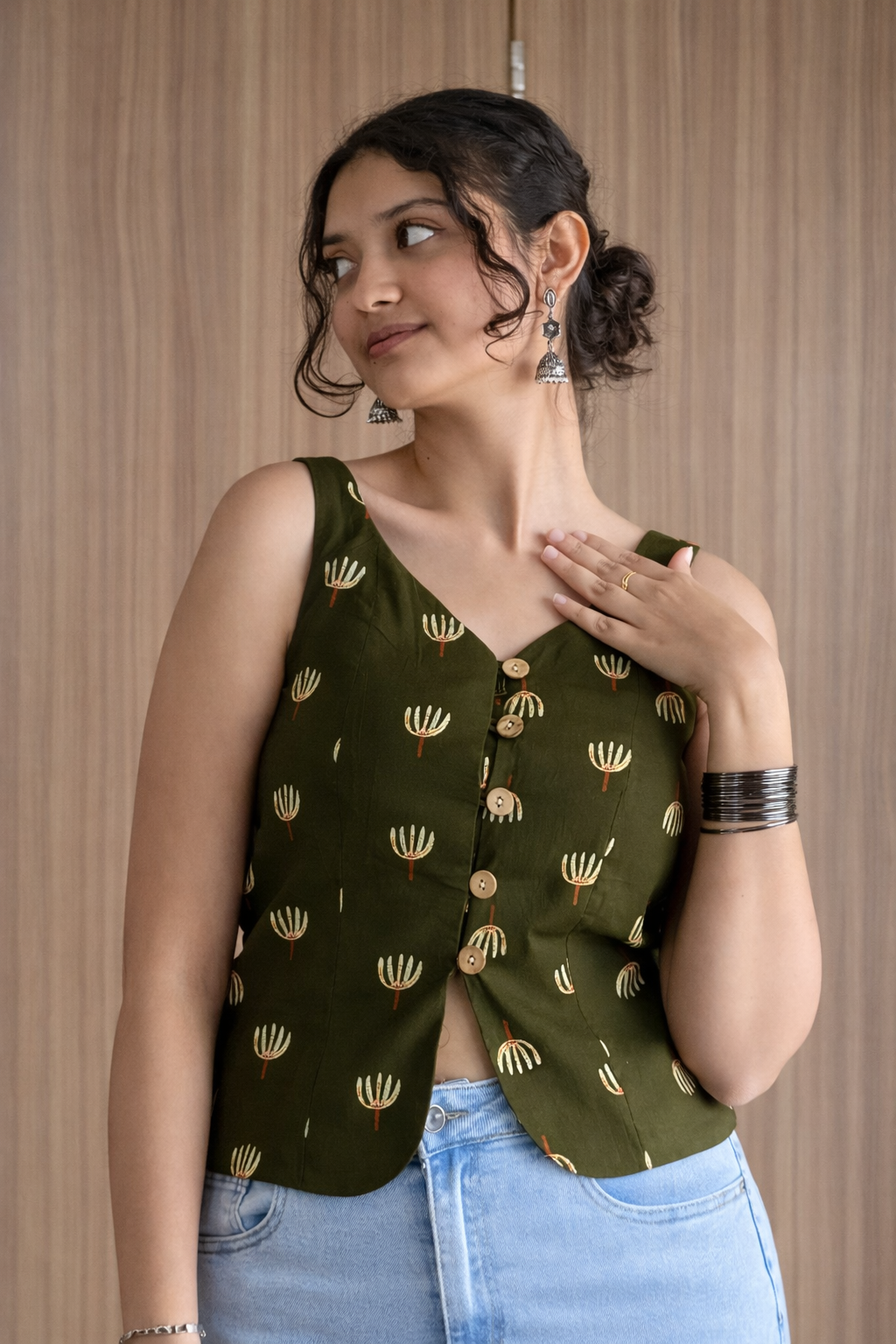 Woman wearing a green patterned top with a wooden background